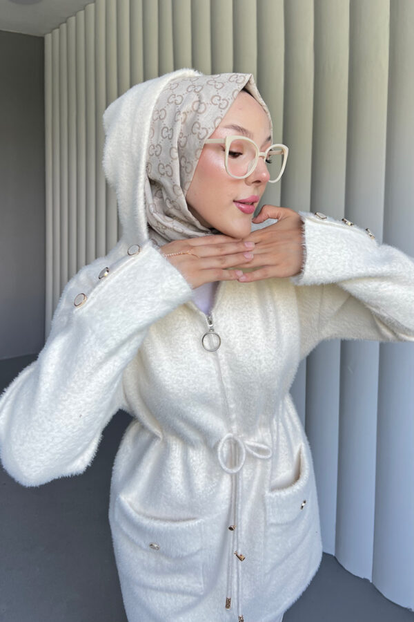 Modern Angora Kapüşonlu Hırka, şıklık ve konforu birleştiriyor. Yumuşacık kumaşı ve pratik kapüşonuyla her ortamda rahatça kullanabileceğiniz zarif bir parça.