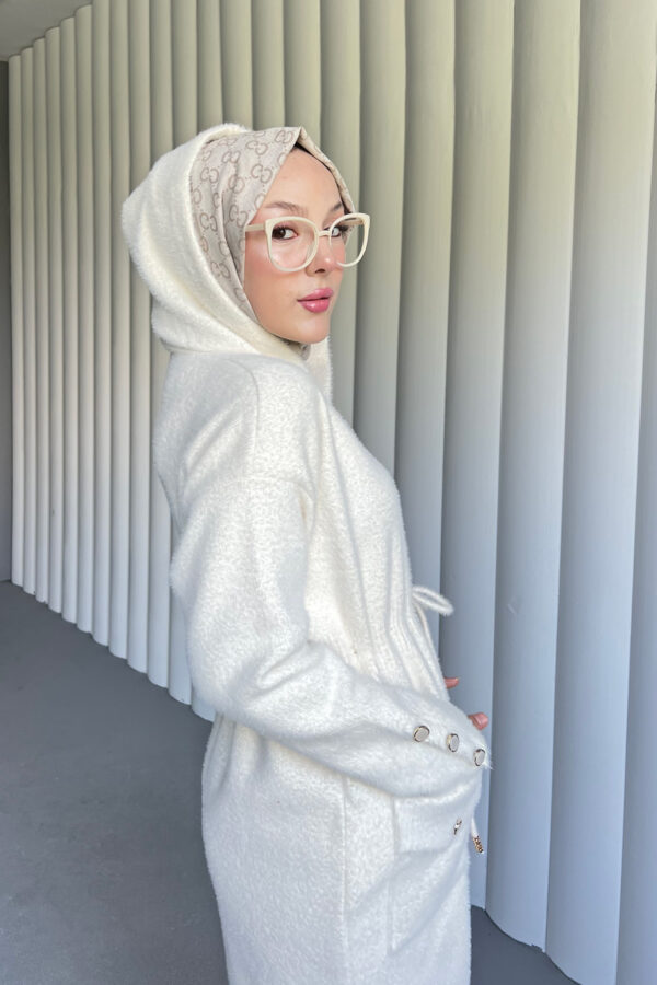 Modern Angora Kapüşonlu Hırka, şıklık ve konforu birleştiriyor. Yumuşacık kumaşı ve pratik kapüşonuyla her ortamda rahatça kullanabileceğiniz zarif bir parça.