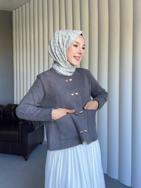 Yumuşacık dokusu ve kalp detaylı düğmeleriyle Aşkın Zarafeti Angora Hırka, standart bedeniyle şıklığı ve konforu bir arada sunar.