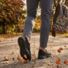 Sokakta yürüyen bir modelin ayağında siyah renkli, bağcıksız, hafif tekstil malzemeden üretilmiş erkek slip-on sneaker ayakkabı.