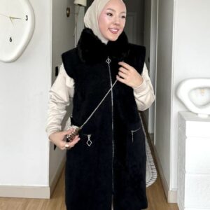 Siyah kürk yakalı fermuarlı uzun yelek, krem pantolonla başörtülü kışlık kombin