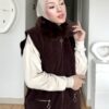 Kahverengi kürk yakalı fermuarlı uzun yelek, krem pantolon ve kazakla kombin